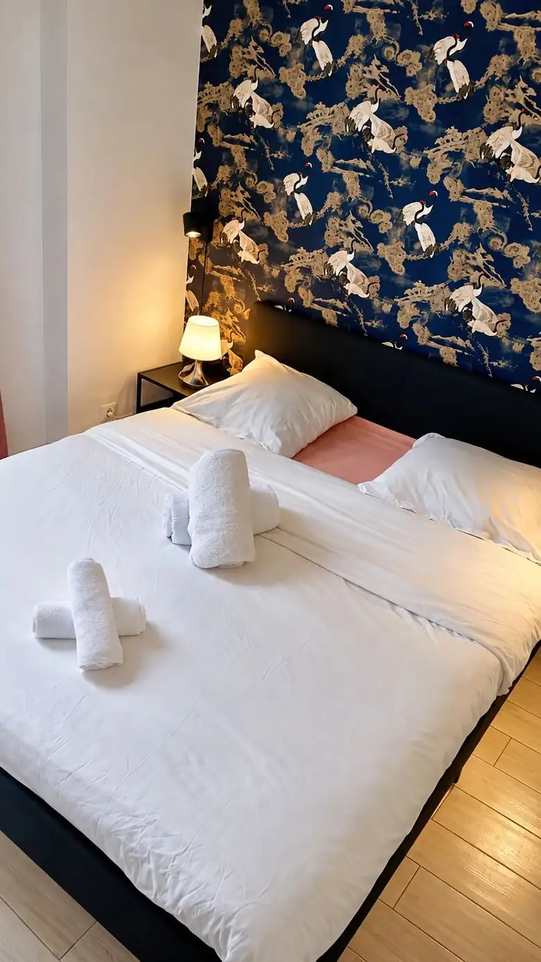 Le coin nuit et son papier peint aux grues — Appartement meublé à Alfortville